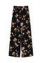Pantaloni neri in crêpe de Chine a fiori con elastico